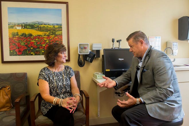 Dr. Matt McMillan talks with patient Shelley Gullifor Thursday in his Methodist Atrium office. MCmillan's practice, MD VIP, offers more personal care for an additional annual fee.