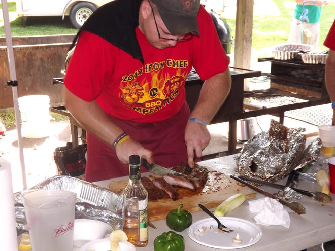 A firerighter chef prepares ribs for tasting during the 2014 Firefighters and Marines Iron Chef BBQ Competition. This year's event will be held from 1-5 p.m. Sept. 13 in Mountainville. PHOTO PROVIDED