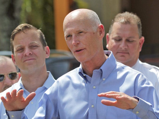 Florida Gov. Rick Scott, middle, speaks at a news conference outside the Miami-Dade Fire Rescue Headquarters Headquarters in Doral, Fla., as South Florida prepare fors Tropical Storm Erika on Friday, Aug. 28, 2015.