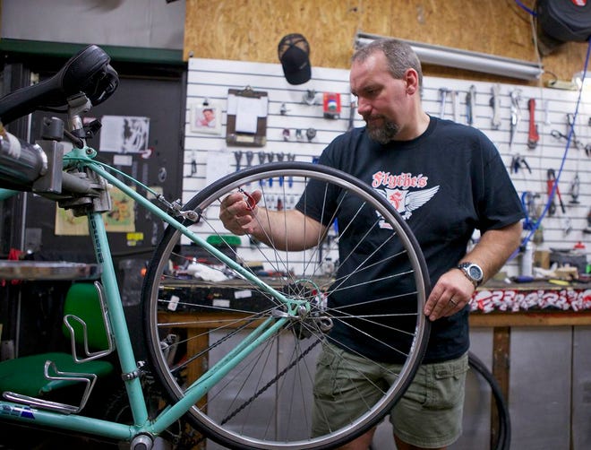 Steve Mercer of Flythe’s Bicycle Shop adjusts the spokes on a bicycle prior to Saturday’s MS Bike Ride.