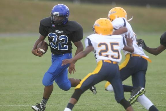 Shelby's George Dunlap carries the ball for the Blue Devils while the Eagles' Keyez Jefferies attempts to tackle Thursday afternoon at Pearley Allen Field.