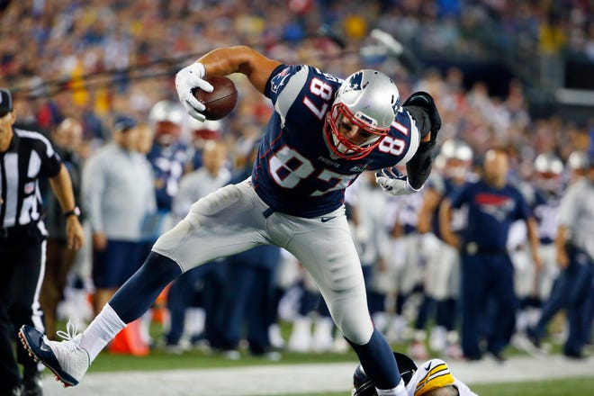 Patriots tight end Rob Gronkowski shakes off Steelers safety Robert Golden Thursday as he heads for a touchdown after catching a pass in the first half of a game in Foxboro, Mass. Gronkowski caught three touchdown passes in New England’s 28-21 victory. THE ASSOCIATED PRESS