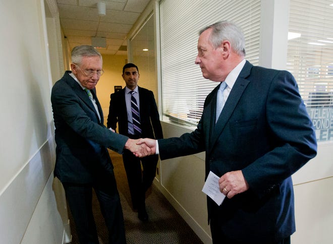Senate Minority Leader Harry Reid of Nev., left, shakes hands with Senate Minority Whip Richard Durbin of Ill.,, right, after speaking with reporters following the Senate vote on the Iran nuclear agreement on Capitol Hill in Washington, Thursday.