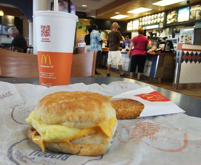 A crowd waits to order breakfast this week at a McDonald's restaurant in Daytona Beach. Starting on Oct. 6, breakfast items such a bacon, egg and cheese biscuit meal (pictured) will be available all day, a move that could spark reaction from competitors. NEWS-JOURNAL/DAVID TUCKER