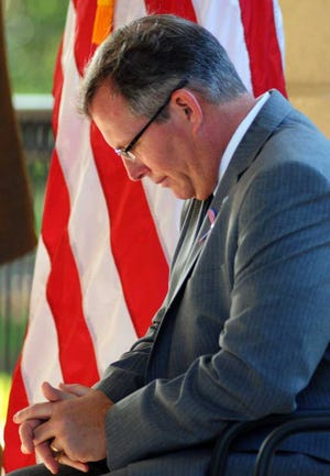 Terry.Dickson@jacksonville.com Tracy Pellet, vice president of academic affairs, bows his head in prayer during Friday's observance for Sept. 11 at College of Coastal Georgia.