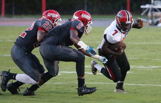 New Bern's Dee Becton tries to outrun Jacksonville's Montrell Pollock (9) and Kyle Lee (22) in Friday's football game.