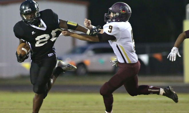 Rutherford's J.J. Willis (20) tries to escape the grasp of Liberty County's Hunter Johnson during Friday's game.