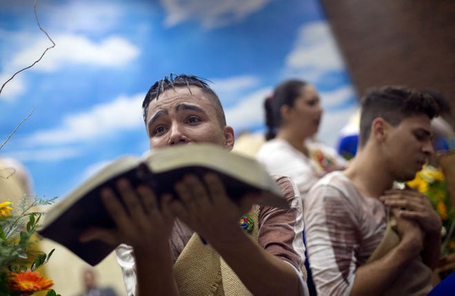 A performer holds a Bible on Monday during a service at the Contemporary Christian Church in Rio de Janeiro. The church was founded and is led by Marcos Gladstone, a gay man who was expelled from his family’s church after coming out as gay in his early 20s. Marcos’ Pentecostal church has 3,000 members in three cities.