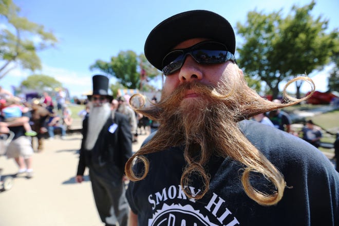 Chad Trusty watches the other division of the Beard and Mustache Competition before being called to the stage in his division of free style beards at the Kansas State Fair in Hutchinson, Kan., Saturday, Sept. 12, 2015.