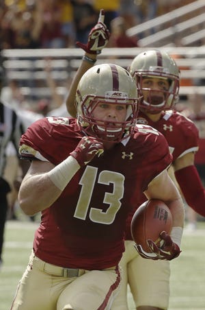 Boston College linebacker Connor Strachan of Wellesley takes an interception to the house Saturday.