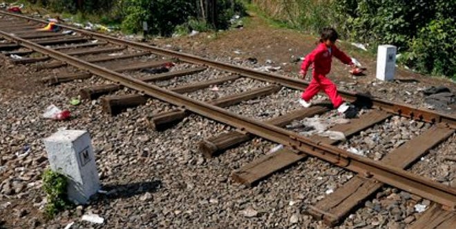 A young girl walks on the railway tracks on the way to a temporary holding center for migrants near the border line between Serbia and Hungary in Roszke, southern Hungary, Saturday, Sept. 12, 2015. Leaders of the United Nations refugee agency warned Tuesday that Hungary faces a bigger wave of 42,000 asylum seekers in the next 10 days and will need international help to provide shelter on its border, where newcomers already are complaining bitterly about being left to sleep in frigid fields.
