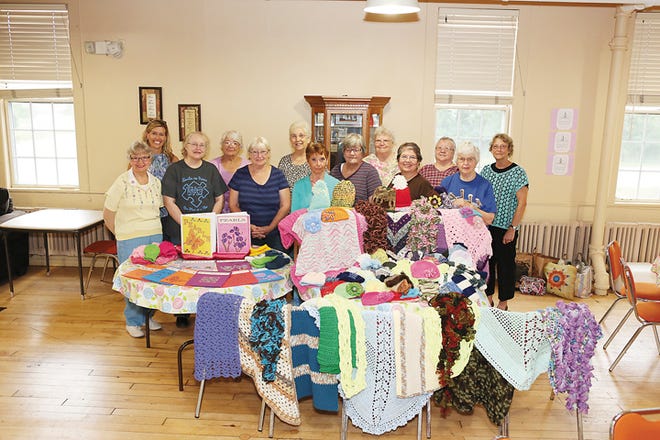 Members of the Prayer Shawl Ministry and the PEARLS Project show off their knitted creations Wednesday at the Tecumseh Senior Center. The hats, shawls, lap robes and other items are given to cancer patients at Saint Joseph Mercy Hospital in Ann Arbor.