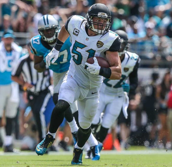 Photos by Gary McCullough For The Times-Union  Jaguars middle linebacker Paul Posluszny runs the ball after making an interception against the Panthers in the first half Sunday.