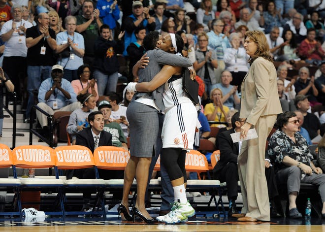 Connecticut's Kelsey Bone, center, hugs assistant coach Jennifer Gillom as fans applaud her and head coach Anne Donovan, right, after Bone scored a career-high 31 points Sunday in the Sun's 86-75 win over the Sky at Mohegan Sun Arena. ASSOCIATED PRESS