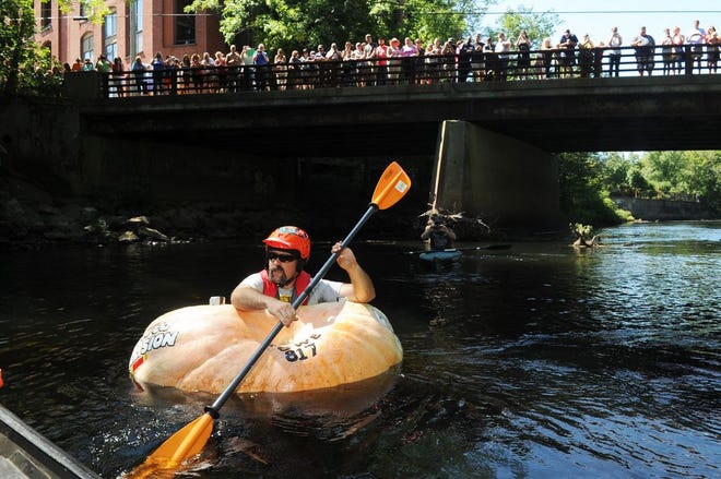 Todd Sandstrum of Easton takes a pumpkin on a 7-mile world record ride down the Taunton River on Saturday, Sept. 5, 2015.