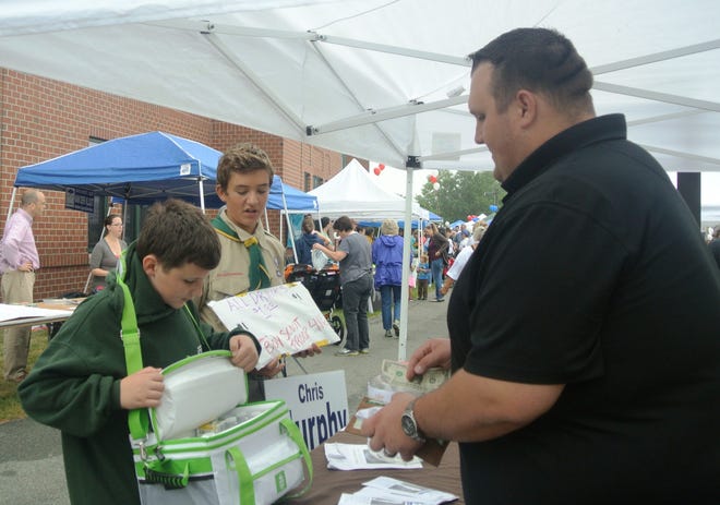 Medford School Committee candidate Chris Murphy buys water from local Boy Scouts during Community Day on Sept. 13. Wicked Local Photo/Nell Escobar Coakley