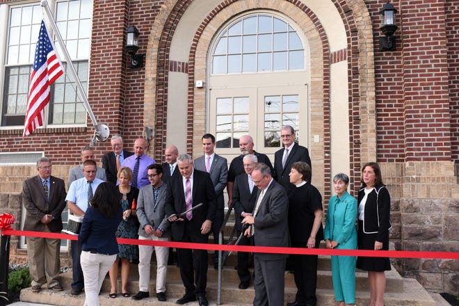 The Duffy School, built in 1870, has been transformed into senior, affordable housing. The new residents, the developer, MEND, and township officials celebrate the grand opening of the restored, renovated and repurposed building. Politicians, residents, developers and former students do the ribbon cutting. Photo by William Johnson