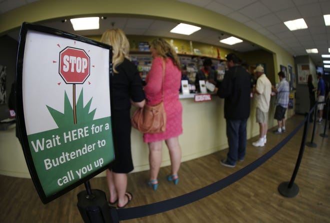 Buyers make their purchases at the counter as a contingent of lawmakers, their staffers and a handful of lobbyists tour one of two retail and grow operations for both medical and recreational marijuana in northeast Denver. The Associated Press