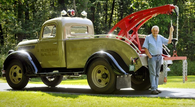 Bruce Webber of Shrewsbury stands next to his fully restored 1939 Ford tow truck at his home on Wednesday. The tow truck used to belong to the Worcester Telegram and The Evening Gazette for towing disabled newspaper delivery vehicles.  T&G Staff/Paul Kapteyn
