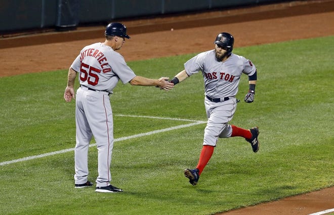 Boston Red Sox third base coach Brian Butterfield, left, greets Dustin Pedroia as he rounds the bases after hitting a three-run home run during a game against the Baltimore Orioles, Wednesday, Sept. 16, 2015, in Baltimore.