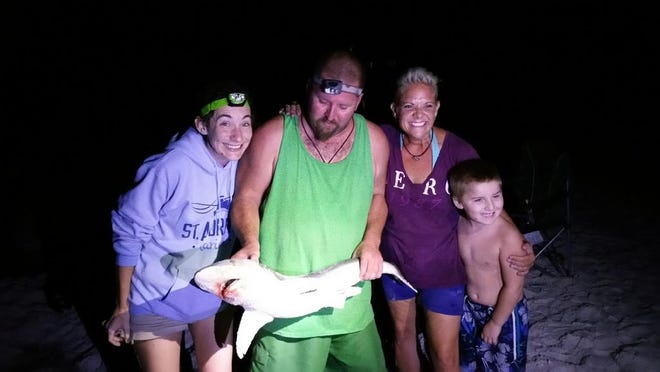 Kasey Miller holds his 4-foot blacktip shark while Cherie Will, Kasey's son Shelby and I cheer him on.