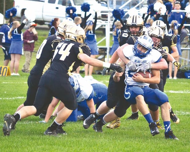 Inland Lakes senior running back Dylan Hopkins gets brought down by a pack of St. Ignace defensive players during the first quarter of a Ski Valley showdown in St. Ignace on Friday night.