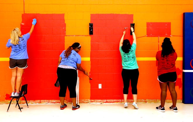 From left, Kelli Sharp, with Hammer Construction; Quintesha Williams and Cristina Ordonez, from Raising Cane's; and Tiara Manning, Hammer Construction, prepare a wall for paint at the Cleveland County YMCA during the annual Day of Caring in Norman. [PHOTO BY STEVE SISNEY, THE OKLAHOMAN]