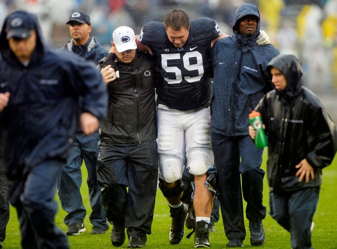 Penn State offensive tackle Andrew Nelson is helped off the field with an injury at the end of the first half of last week's game against Buffalo. The Nittany Lions' line has had troubles protecting quarterback Christian Hackenberg in the first two games of the year. (Chris Dunn/York Daily Record)