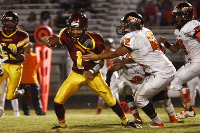 Petersburg High School's quarterback Stanley Davis (1) tries to escape the James Monroe defenseman Chris Carter (42) in the second quarter of the Wave's 51-6 loss to the Jackets at home on Friday, Sept. 18, 2015. Scott P. Yates/Progress-Index.com