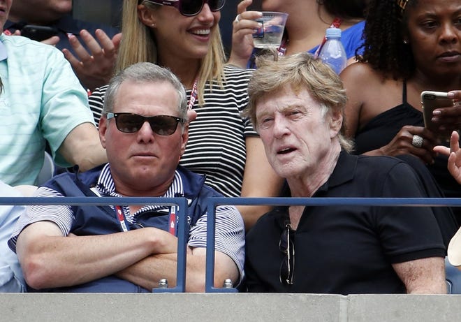 David Zaslav, Discovery Communications CEO, left, and actor Robert Redford watch the U.S. Open tennis tournament last Saturday. According to the Associated Press, Zaslav was the best-paid chief executive of a large American company last year, with total compensation of $156.1 million. AP PHOTO