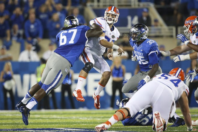 Florida's Will Grier is hit by Kentucky's Cory Johnson, left, after throwing a pass during the first half Saturday in Lexington, Kentucky. ASSOCIATED PRESS/DAVID STEPHENSON