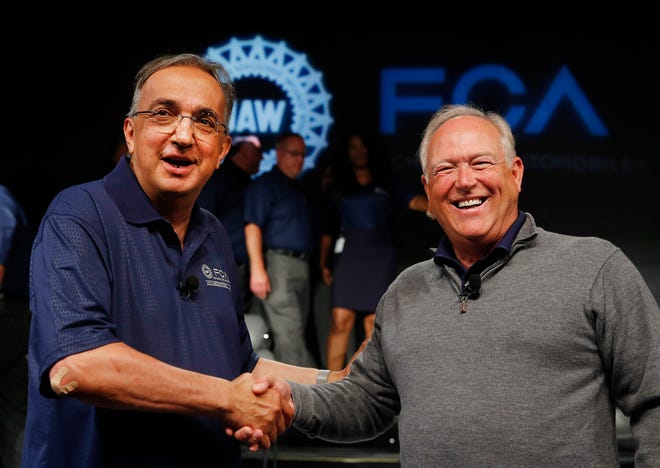 FILE - In this July 14, 2015, file photo, Fiat Chrysler Automobiles CEO Sergio Marchionne, left, and United Auto Workers President Dennis Williams shake hands during a ceremony to mark the opening of contract negotiations in Detroit. The United Auto Workers union and Fiat Chrysler have reached a tentative deal on a new contract for about 40,000 workers that will serve as a pattern for pacts with General Motors and Ford. Terms of the deal were not disclosed Tuesday, Sept. 15, but both sides said a news conference would be held later in the evening with Williams and Marchionne. (AP Photo/Paul Sancya, File)