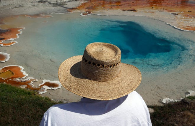 Visitors to the Lower Geyser Basin in Yellowstone National Park are in awe of the amazing colors created by the bacteria and thermophile living in the hot water in Silex Spring. (Mark Boster/Los Angeles Times/TNS)