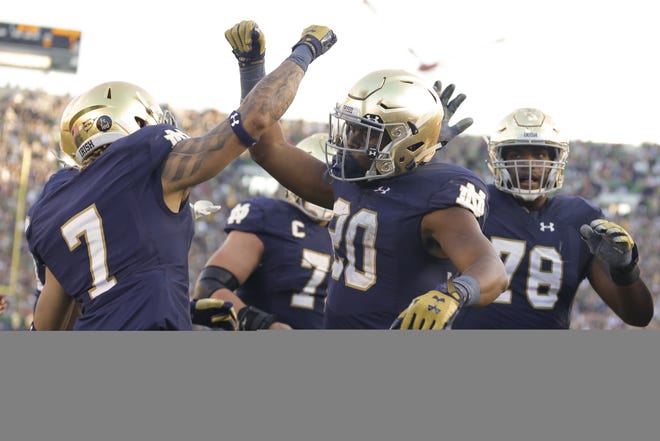 Notre Dame running back C.J. Prosise (20) celebrates a touchdown with Notre Dame wide receiver Will Fuller (7) during the second half of an NCAA college football game against Georgia Tech in South Bend, Ind., Saturday, Sept. 19, 2015. Notre Dame defeated Georgia Tech 30-22. (AP Photo/Michael Conroy)