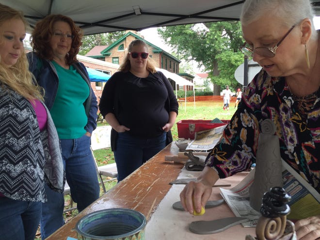 Samantha Brown, left, Cinda Sausaman and Danielle Sausaman watch as ceramicist Kathy Adams crafts clay into an angel Saturday during the 27th annual Edwards Place Fine Art Fair. PHOTO BY TAMARA BROWNING/THE STATE JOURNAL-REGISTER