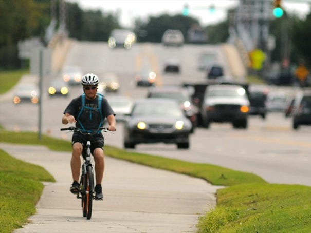 Bicyclists ride along the multi-use path next to Eastwood Road in Wilmington.