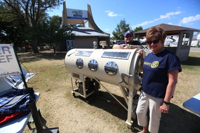 Rotary Club members Aaron Walker and Carol Berger stand with the Iron Lung that are on display at the Rotary Club booth Thursday, Sept. 17, 2015 at Kansas State Fair.