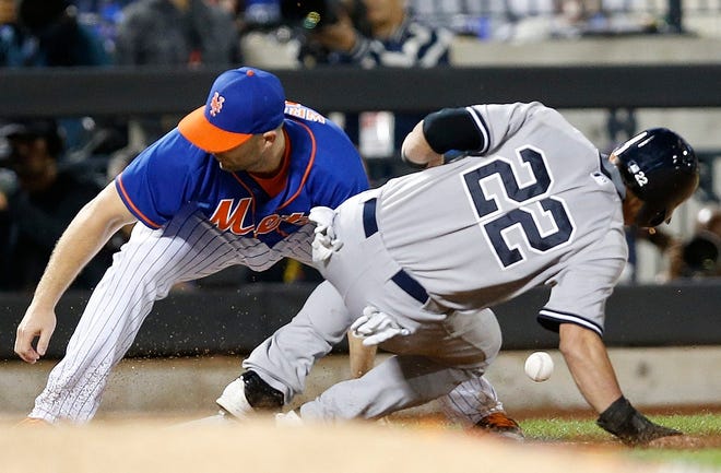 Mets' David Wright, left, loses track of the throw for an error as the ball bounces behind him as Yankees' Jacoby Ellsbury (22) slides safely into third base in the sixth inning.