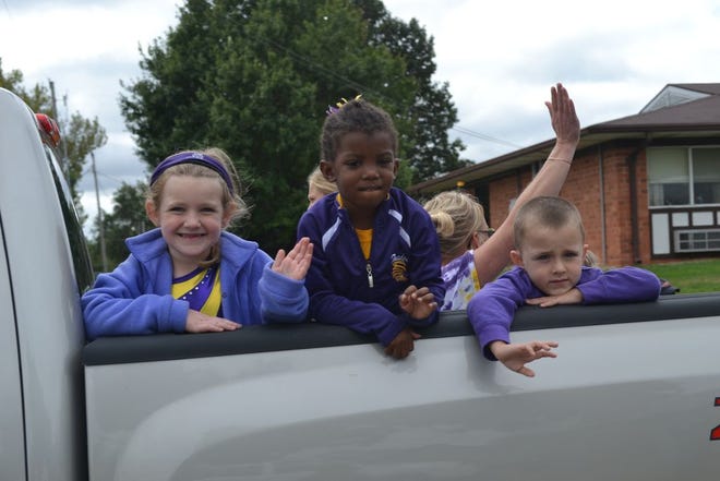Members of the Canton Family YMCA Tumbling Tornadoes wave from their float in the Canton Friendship Festival Parade Saturday morning.