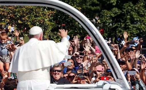Pope Francis waves to the crowd from the popemobile during a parade in Washington, Wednesday, Sept. 23, 2015, following a state arrival ceremony at the White House hosted by President Barack Obama. (AP Photo/Alex Brandon, Pool)
