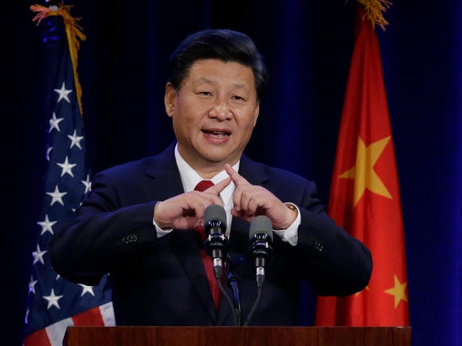 Chinese President Xi Jinping talks about how the Chinese symbol for the word "people" resembles two sticks supporting each other as he speaks Tuesday at a banquet in Seattle.