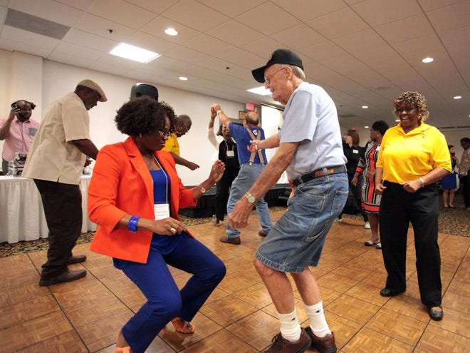 Dr. Folakemi Odedina, left, director of health disparities at the UF Health Cancer Center, dances with WWII veteran Horace Brown, along with other doctors and medical officials during the 2015 Gainesville Community Health and Empowerment Summit.