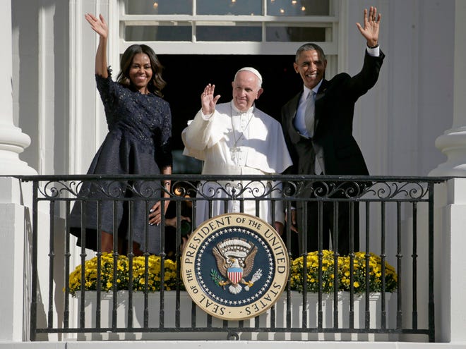 President Barack Obama, first lady Michelle Obama and Pope Francis wave to the crowd on the South Lawn from the Truman Balcony of the White House in Washington on Wednesday.