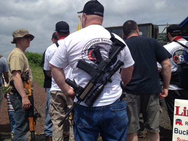 A man carries a firearm during a rally inside Morrisville's Williamson Park in May 2013.