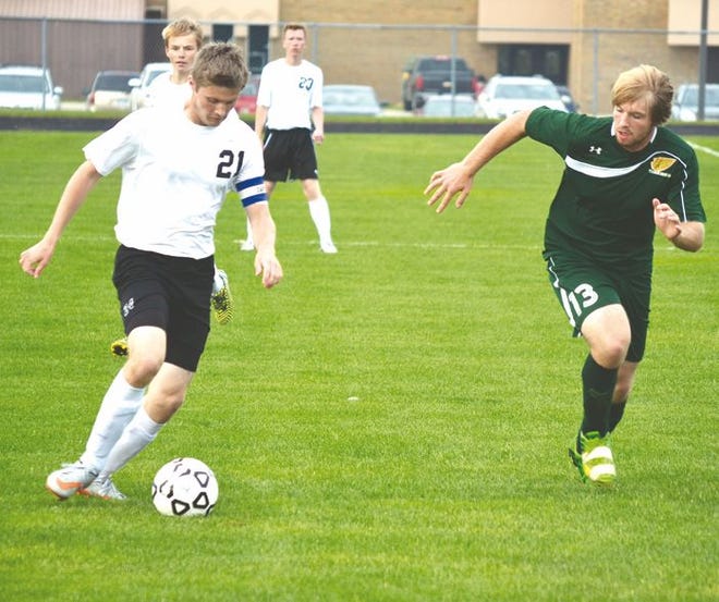 Cheboygan senior midfielder Brandon St. Clair (21) pushes the ball upfield while Forest Area's Zack Paulus (13) chases during the first half of a soccer contest in Cheboygan on Thursday. St. Clair scored a goal and assisted on another to lead the Chiefs to a 3-0 victory.