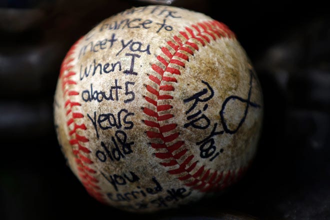 A message is written on a baseball placed on a statue of New York Yankees hall of fame catcher Yogi Berra at the Yogi Berra Museum, Thursday, Sept. 24, 2015, in Little Falls, N.J. Berra died Tuesday at the age of 90.