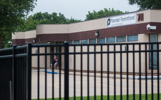 Patient escort Ellen Baker uses her phone Aug. 10 while sitting outside the Columbia Planned Parenthood clinic, 711 N. Providence Road. University of Missouri Health Care has set a date for ending the privileges it had given to the doctor who provides abortions at the clinic.