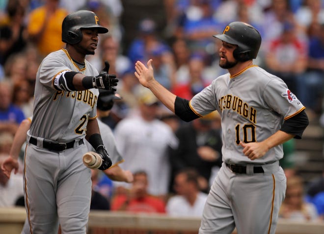 Pittsburgh Pirates' Jordy Mercer (10) celebrates with teammate Gregory Polanco (25) after scoring on a Gerrit Cole single during the third inning of a baseball game against the Chicago Cubs, Friday, Sept. 25, 2015, in Chicago. (AP Photo/Paul Beaty)