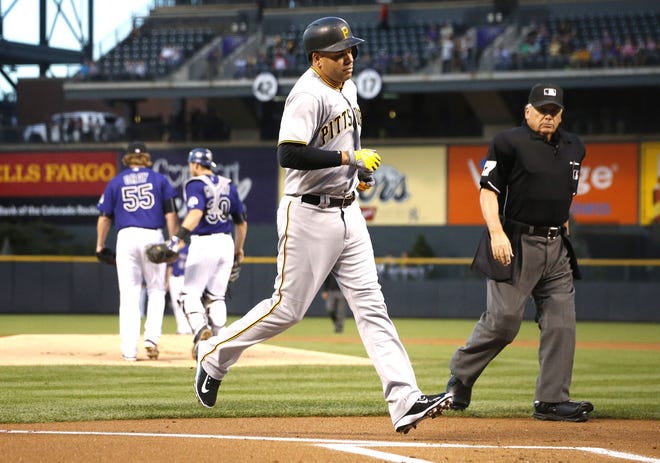 Pittsburgh Pirates' Aramis Ramirez, front left, heads to home plate after hitting a solo home run as home plate umpire Larry Vanover, front right, looks on in the first inning of a baseball game against the Colorado Rockies, Monday, Sept. 21, 2015, in Denver. (AP Photo/David Zalubowski)
