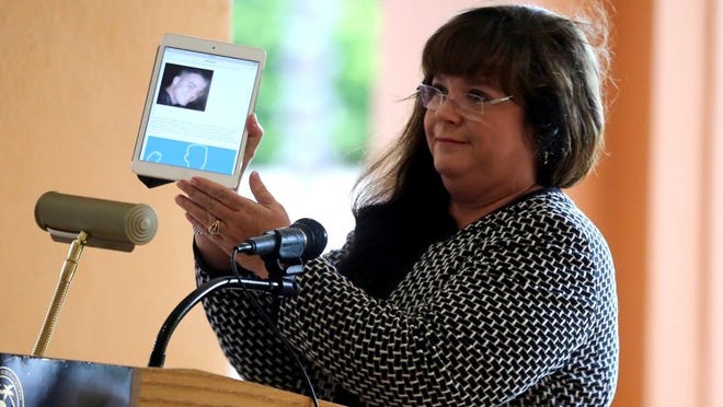 Kerry Torres holds up a picture of her son Kenny while making remarks during a National Day of Remembrance for Murder Victims ceremony at the Palm Beach Shores community center Friday, September 25, 2015. (Damon Higgins / The Palm Beach Post)